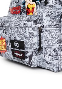 Mochila temática de cómic con un estampado en blanco y negro, acentos rojos y logotipos de DC y Eastpak. Detalles decorativos de Wonder Woman.