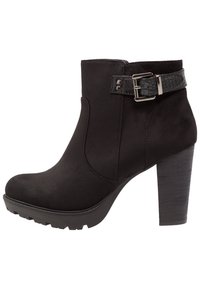Bottines noires en daim avec un talon épais noir, arborant une sangle en cuir texturé et un accent en boucle, avec une semelle crantée.