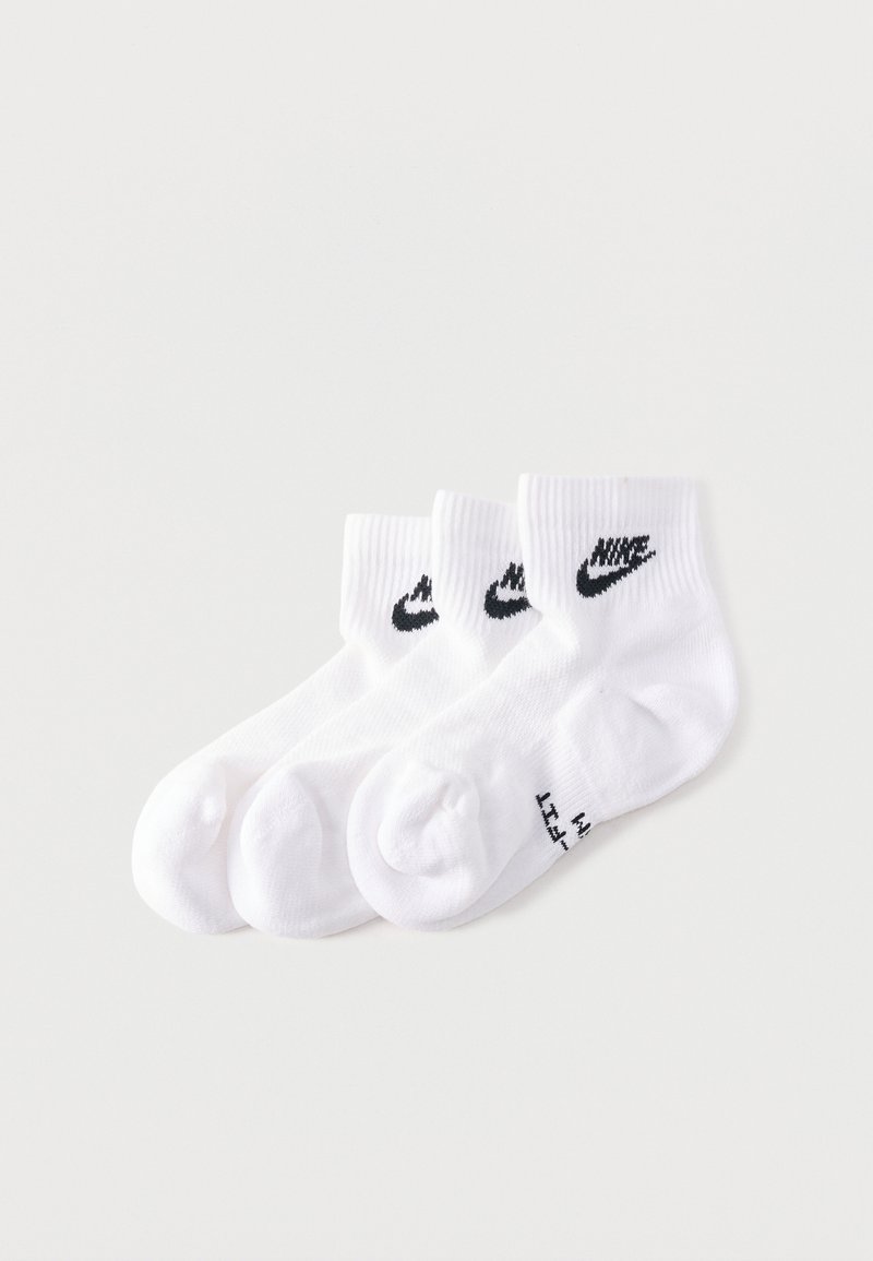 Trois paires de chaussettes blanches courtes avec des logos Nike en forme de virgule noirs, empilées côte à côte sur un fond blanc.