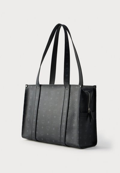 Μαύρη τσάντα ώμου από ανάγλυφο δέρμα με διακοσμητική επιφάνεια, διαθέτει δύο μακριές λαβές και πλαϊνή τσέπη με φερμουάρ.