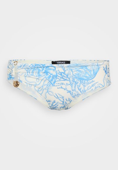 Versace bikinių apatinė dalis, pagaminta iš šviesios grietinėlės spalvos audinio, puošto išraiškingais mėlynų medūzų ir koralų raštais; auksinės logotipo detalės akcentas.