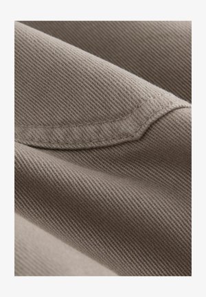 Brauner Baumwollstoff mit feiner diagonaler Webart, der eine glatte Textur und einen subtilen Glanz aufweist; der Rand hat eine saubere genähte Naht.