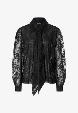 Zwarte kanten blouse met een kraag, lange poffende mouwen en een strikdetail bij de hals. Doorzichtige textuur met florale patronen overal.