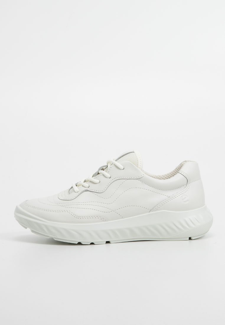 Zapatilla de cuero blanca con parte superior texturizada, punta redondeada y suela gruesa. Presenta un diseño de cordones y un sutil detalle en relieve en el costado.