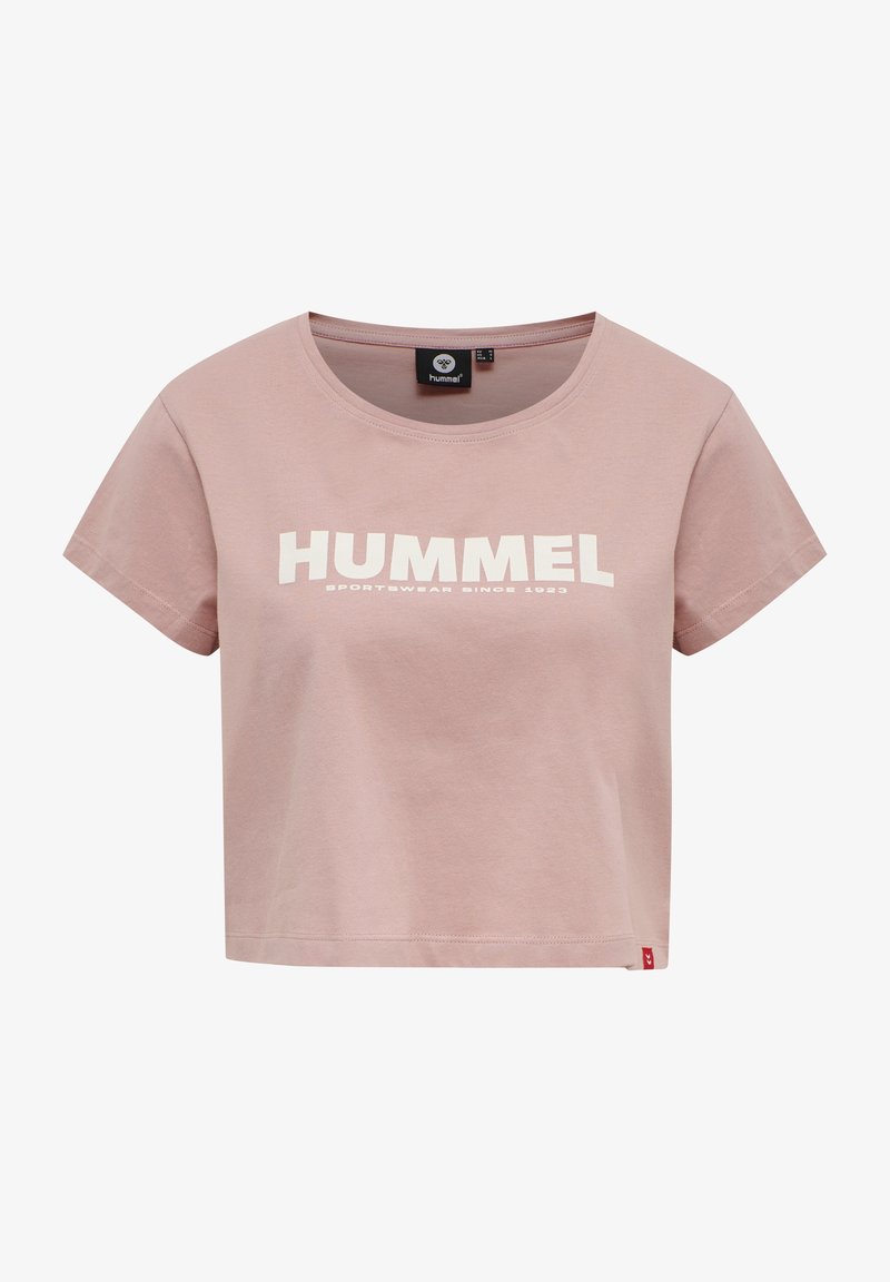 Camiseta cropped de color rosa claro, hecha de algodón, con un escote redondeado y letras en bloque blancas que dicen "HUMMEL" y "SPORTWEAR SINCE 1923."