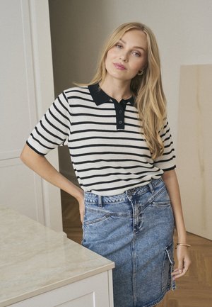 Gestreept kortemouwen polo-shirt in wit en zwart, met een zwarte kraag en een drieknops sluiting; gecombineerd met een denim pencil skirt.