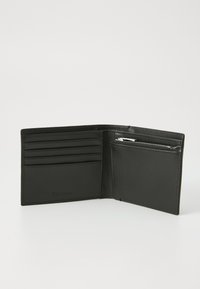 Portefeuille en cuir noir avec plusieurs emplacements pour cartes et un compartiment zippé. Texture lisse avec logo de la marque embossé à l'intérieur.