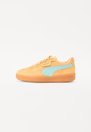 Puma Sneaker aus orangefarbenem Wildleder mit hellblauen Akzenten, flachen Schnürsenkeln, runder Zehenpartie und semitransparenter Gummisohle. Retro-Design.