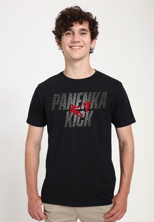 Young man smiling, wearing a black T-shirt with "PANEUKA KICK" text and red graphic of two people performing martial arts moves.