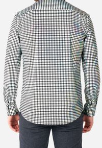 Lange mouwen shirt van lichte stof met een ruitpatroon van kleine zwart-witte vierkanten met iriserende accenten.