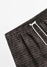 Černé šortky s bílou mřížkovanou vzorem, elastickým pasem a bílou šňůrkou na stažení. Vyrobeny z měkkého materiálu s texturovaným povrchem.