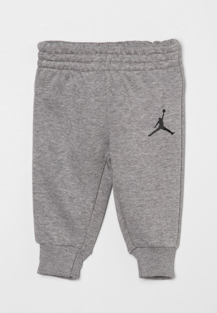 Joggers en coton gris avec une taille élastique et des poignets aux chevilles, affichant un logo Jordan noir sur le côté. Texture lisse et design décontracté.