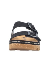 Czarny sandał na płaskiej podeszwie z dwiema regulowanymi klamrami, srebrnymi klamrami, fakturowaną górą, korkową wkładką i jasnym przeszyciem wzdłuż podeszwy.
