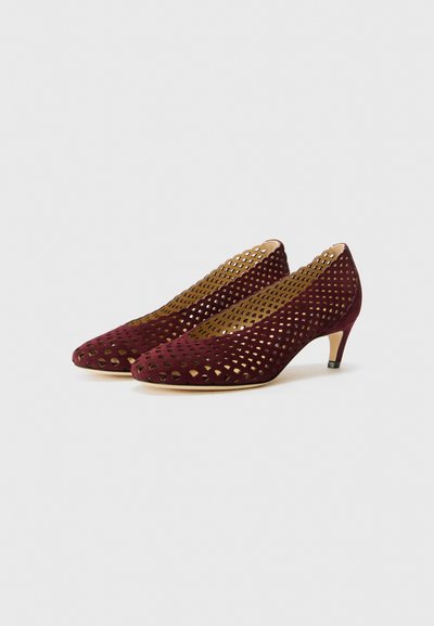 Scarpe con tacco alto color bordeaux con motivi ritagliati, materiale scamosciato, punta appuntita e tacco piccolo decorato.