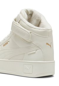 Weißer High-Top-Sneaker aus Leder mit gepolstertem Kragen, Klettverschluss und goldenen Akzenten. Logo an der Seite und Ferse angezeigt.