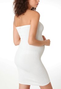 Weißes, geripptes Röhrenkleid mit dehnbarem Material, figurbetonter Silhouette und trägerlosem Design, das einen schlichten Saum und keine sichtbaren Verschlüsse aufweist.
