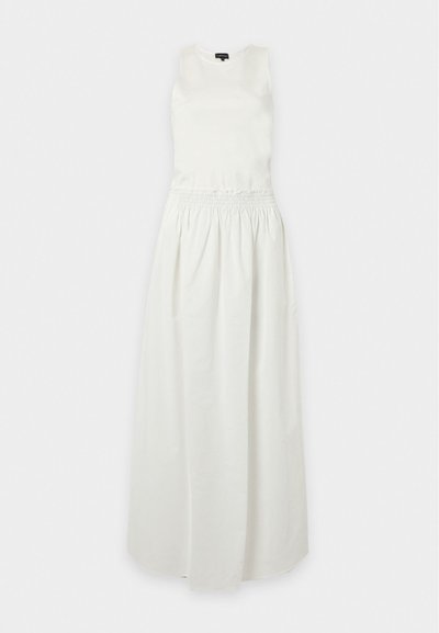 Robe longue blanche sans manches avec taille froncée et encolure ronde posée à plat sur fond blanc.