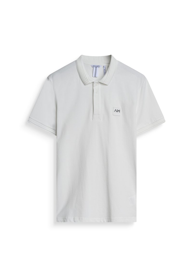 Polo bianca in cotone, con colletto a coste, maniche corte e un'etichetta quadrata con logo sul lato sinistro del petto. Design semplice.
