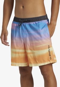 Shorts de bain colorés avec un motif dégradé allant du bleu à l'orange, une taille élastique avec un cordon de serrage, et un détail de logo sur le côté.
