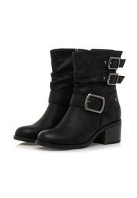 Bottes en cuir noires mi-mollet avec trois grandes boucles en argent, talons carrés et tige légèrement affaissée.