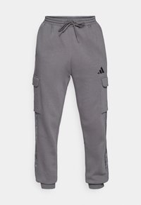 Pantalones de chándal cargo grises con cintura elástica y cordón, que cuentan con bolsillos laterales y detalles del logo en negro, tejido texturizado y puños ajustados.
