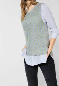 Gray sleeveless knit top with a textured pattern over a light blue collared shirt. Paired with black distressed jeans.