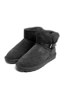 Las botas de tobillo de ante negro cuentan con un suave forro de piel, una puntera redondeada y un detalle con hebilla en el lateral. La suela es texturizada para ofrecer agarre y estabilidad.