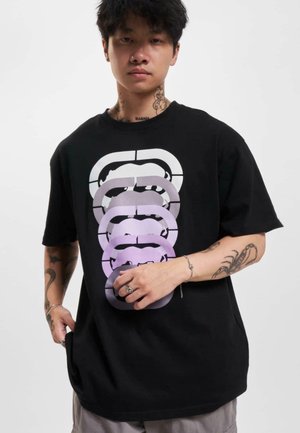 Sort bomulds T-shirt med et gradientdesign af overlappende ansigtstræk i nuancer fra hvid til lilla, løs pasform med korte ærmer.