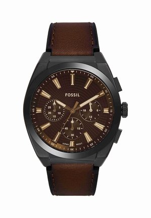 Ronde zwarte Fossil polshorloge met bruine wijzerplaat, gouden uurmarkeringen, drie subdials en een bruine leren band, die 9:10:38 aangeeft.
