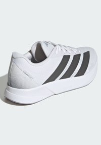 Weißer Sportschuh mit Mesh-Obermaterial, schwarzen Streifen an den Seiten, gepolsterter Schuhkragen und einer strukturierten Sohle, die mit "LIGHTMOTION" beschriftet ist.