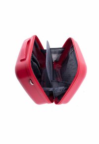 Red hard-shell suitcase open, showing black interior with divider, adjustable strap, and side zipper pocket.