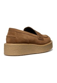 Brun mocka slip-on sko med en tjock strukturerad plattformssula och rund tå, med ett dekorativt band och sömnadsdetaljer.