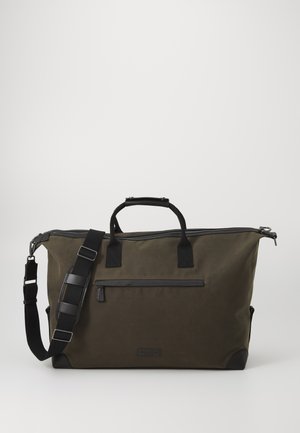 Olijfgroene canvas weekendtas met zwarte accenten, ritssluiting, twee handgrepen aan de bovenkant en een verstelbare schouderriem. Voorzien van een voorvak met rits.