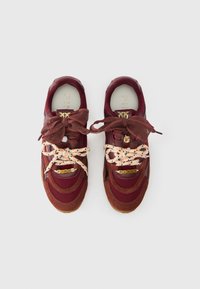 Αθλητικά παπούτσια από καστόρι και διχτυωτό ύφασμα σε μπορντό χρώμα με κρεμ λεπτομέρειες, υφασμένες κορδόνια και χρυσή λεπτομέρεια λογότυπου στη γλώσσα, με στρογγυλεμένο σχήμα μύτης.