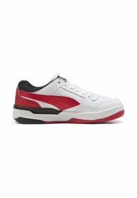 Białe i czerwone buty sportowe z gładką skórzaną powierzchnią, z czarnym akcentem, teksturowaną gumową podeszwą oraz wzmocnionym czubkiem.