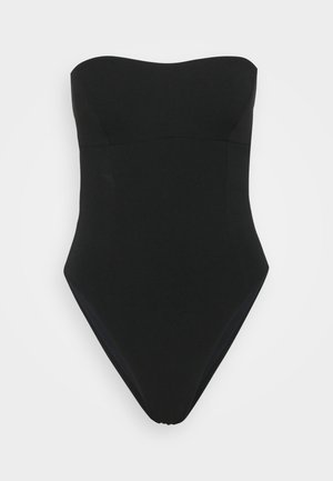 Bañador negro sin tirantes con una textura suave y mate. Presenta un cuerpo ajustado y un diseño de pierna alta. Sin adornos adicionales.