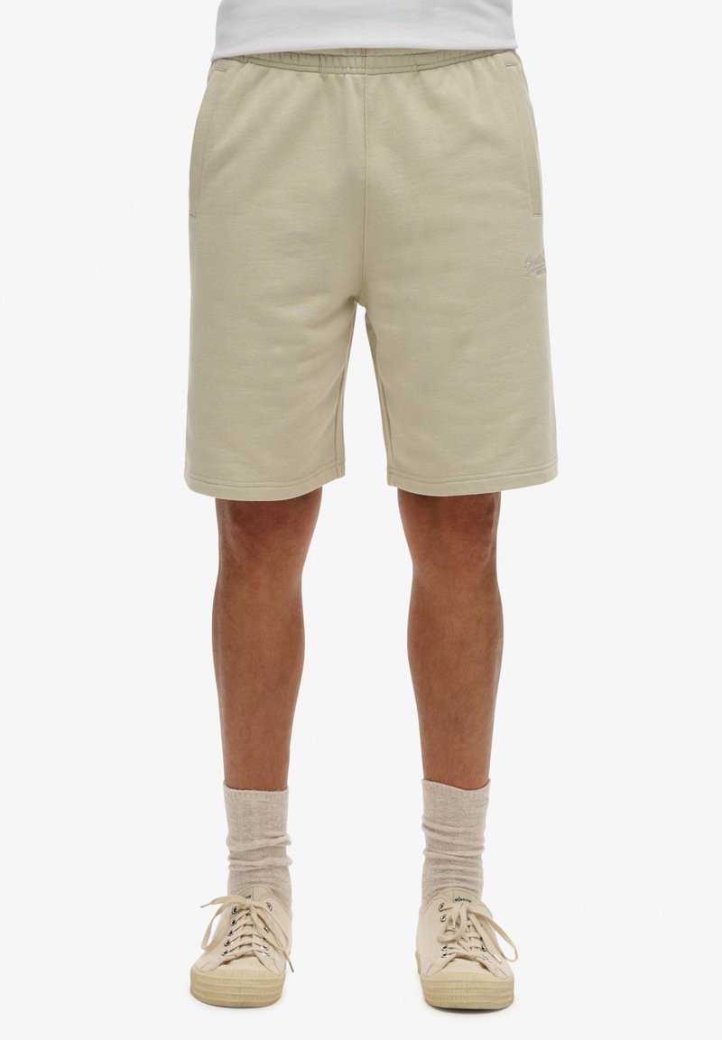Beige shorts gjorda av strukturerad tyg, med resårmidja, sidofickor och en liten broderad logotyp fram.
