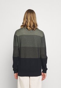 Maglione lavorato a maglia con un motivo testurizzato, caratterizzato da strisce orizzontali di colore verde scuro e blu navy. Maniche lunghe e polsini a coste.