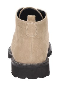 Stivale alla caviglia in suede beige con zona posteriore rialzata, cuciture rinforzate e suola in gomma nera con battistrada testurizzato per una migliore aderenza.