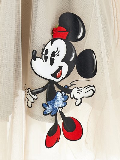 Minnie Mouse grafika uz bēša tilla, ar melnu kontūru, sarkanām kurpēm, ziedainu zilu svārku un cepuri ar sarkanu akcentu.
