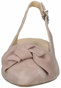 Chaussure plate en suédine rose clair avec une bride à la cheville et un détail de nœud à l'avant. Texture lisse et forme arrondie. Semelle plate.