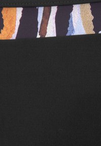 Tissu noir avec une texture ribbrée, présentant une taille ornée d'un motif abstrait coloré de rayures dans différentes teintes.