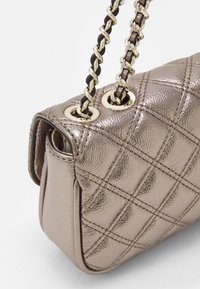 Kovově bronzová kabelka s prošívanou texturou, zdobená zlatými prvky a dvojitým řetízkovým popruhem. Kompaktní design se strukturovaným tvarem.