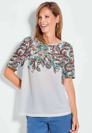 Luftige, weiße Bluse mit aufwendigen Paisley-Stickereien in Teal, Orange und Braun an den Ärmeln und der Vorderseite. Runder Ausschnitt und kurze Ärmel.