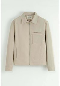 Veste beige avec fermeture éclair à l'avant, col ouvert, manches longues et deux poches latérales. Comprend une poche poitrine zippée. Fabriqué en tissu lisse.