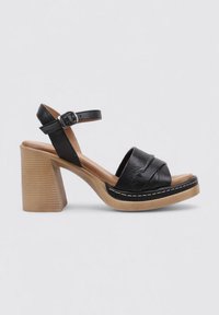 Sandalias de tacón negro con una tira ancha y detalle de hebilla, con parte superior de cuero texturizado y un tacón de bloque de madera apilado.