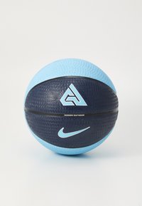 Basketbal s textúrovaným povrchom, tmavomodrou a svetlomodrou farebnou schémou, obsahujúci logá a nápis "VNÚTRI/NA OBCI" vytlačený na strane.