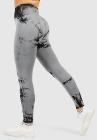 Leggings grigi con un motivo tie-dye nero, vita alta e design alla caviglia. Realizzati in tessuto elastico per comfort e libertà di movimento.