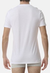 Vit kortärmad t-shirt i bomull med klassisk rund hals. Baksidan har en slät yta utan synliga logotyper eller mönster.