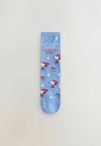 Light blue socks featuring cartoon Snoopy in a red hat with festive accents, scattered designs, and white diamond patterns. Soft knit material.